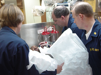 a photo of medical staff helping a person in a warming suit