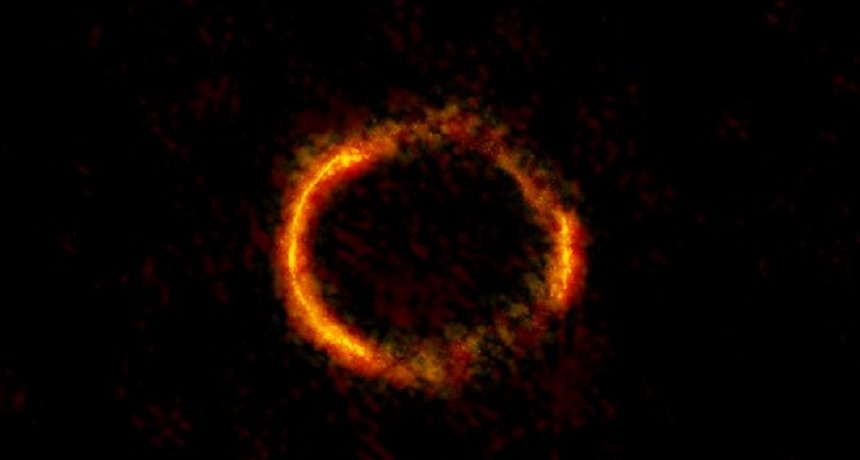 This distant galaxy — distorted into a ring shape — is visible to people on Earth because it sits behind a gravitational lens.