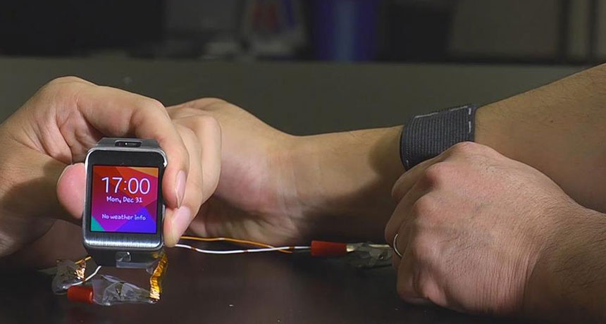A stretchable battery has been sewn inside an elastic strap worn on the arm, at right. The battery can power a smart watch.