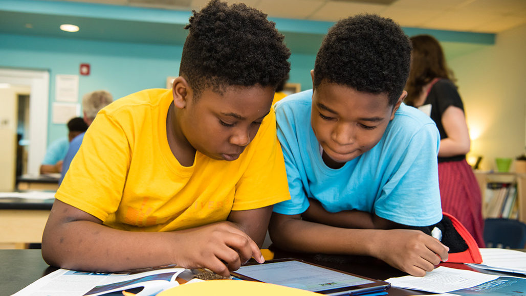 two students looking at a tablet