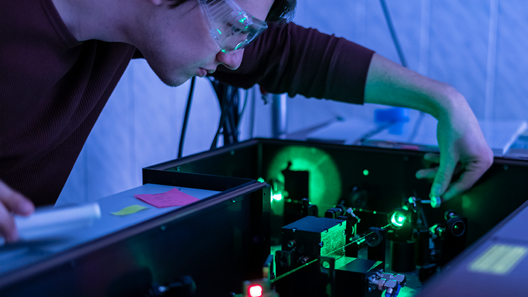 a person looking at a photon beam in a lab