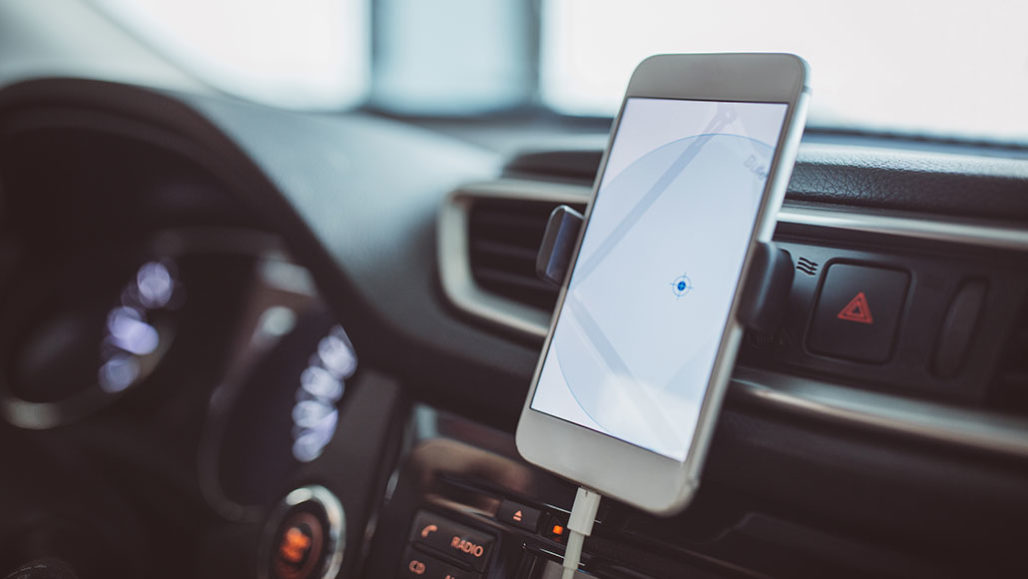 a phone attached to a car dashboard, the screen is showing a map