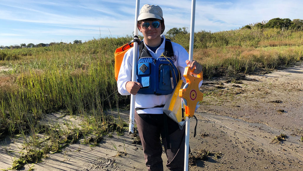 a photo of Andrew Brinton in a salt marsh