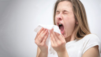 a photo of a woman mid-sneeze or mid-cough