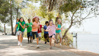 group of children at camp running along a path
