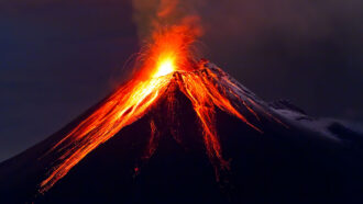 a photo of a volcano erupting with red hot lava pouring down the sides