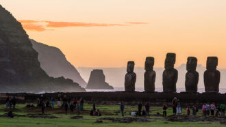 a photo of tourists in front of Easter Island statues