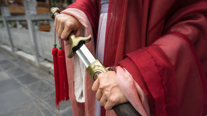 a photo of the hands of a Chinese warrior drawing a sword