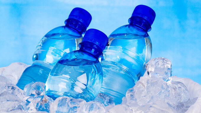 three bottles of water mostly submerged in ice