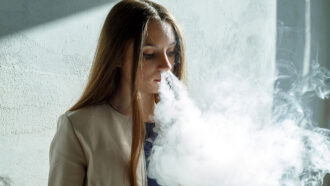 a photo of a girl vaping and blowing smoke out of her nose