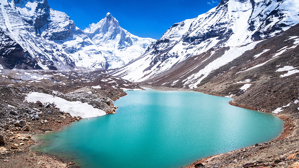 a green glacial lake high in the Himalayas