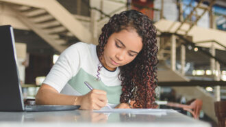 a photo of a girl taking notes by hand