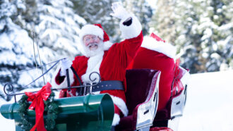 a photo of Santa sitting in a sleigh in a wintery landscape, he is waving at the camera