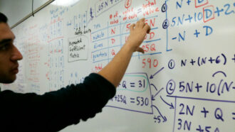 a student at a whiteboard full of algebra problems
