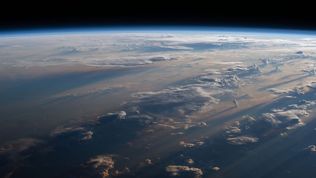 a photo of the Earth's atmosphere from the International Space Station above a cloudy Philippine Sea