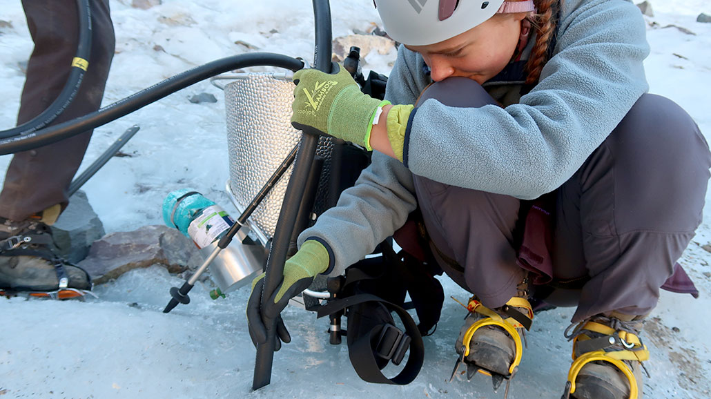 a photo of Ellery drilling into a glacier using steam