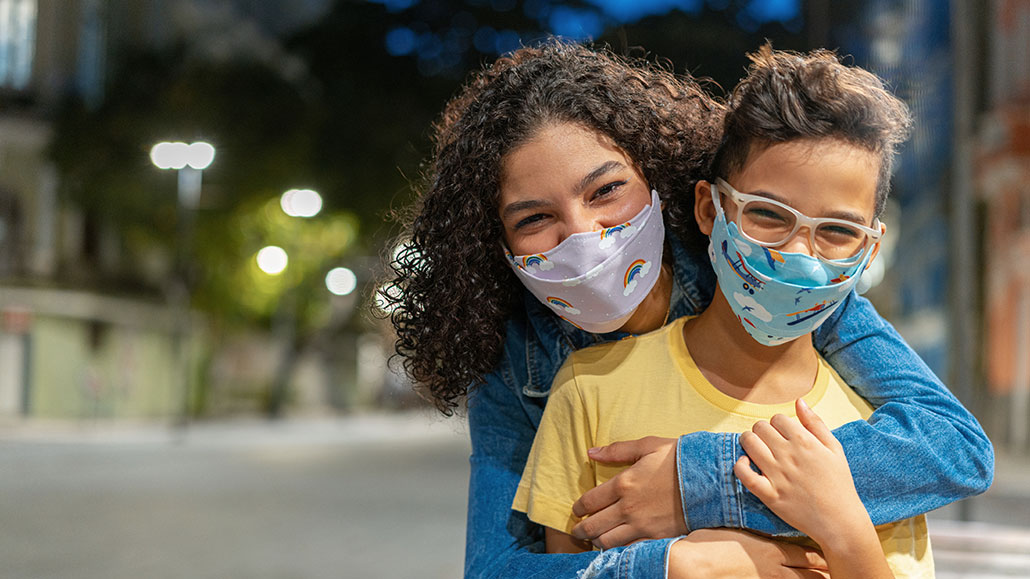 kids wearing face masks and hugging