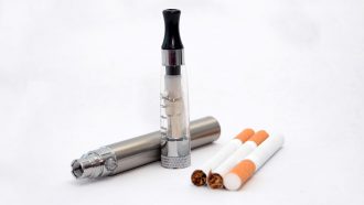 a photo of electronic cigarettes and regular cigarettes on a white background