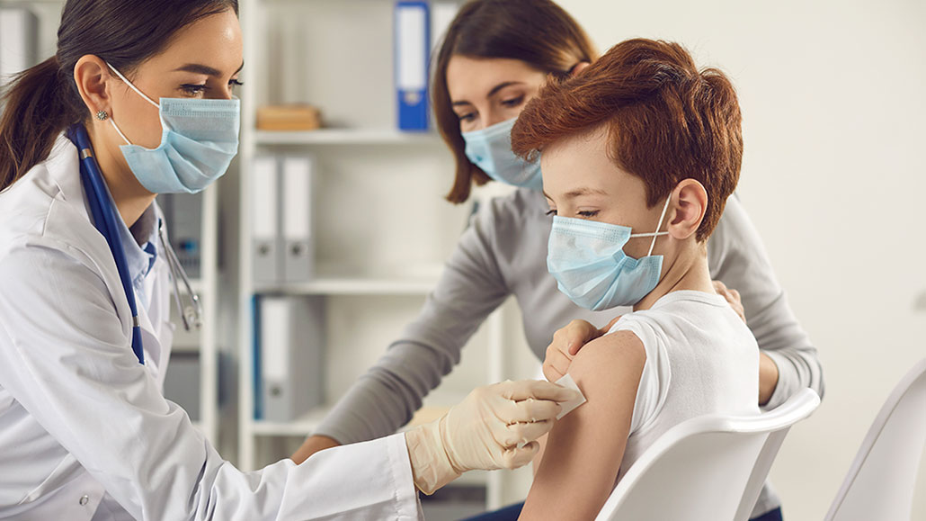 a red-haired kid getting his arm prepped for a shot