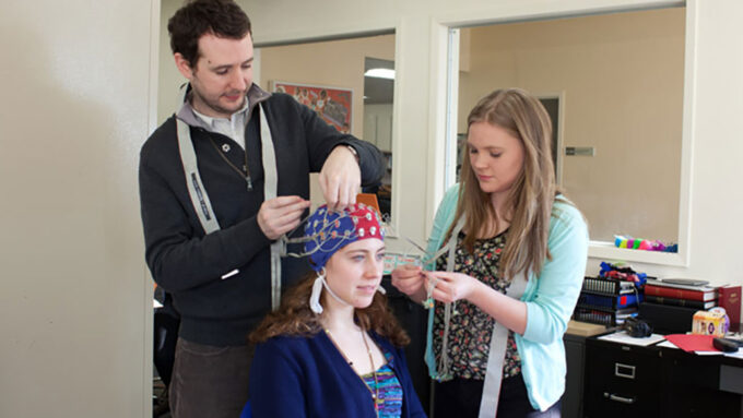 Scientists practice attaching probes to another student's head