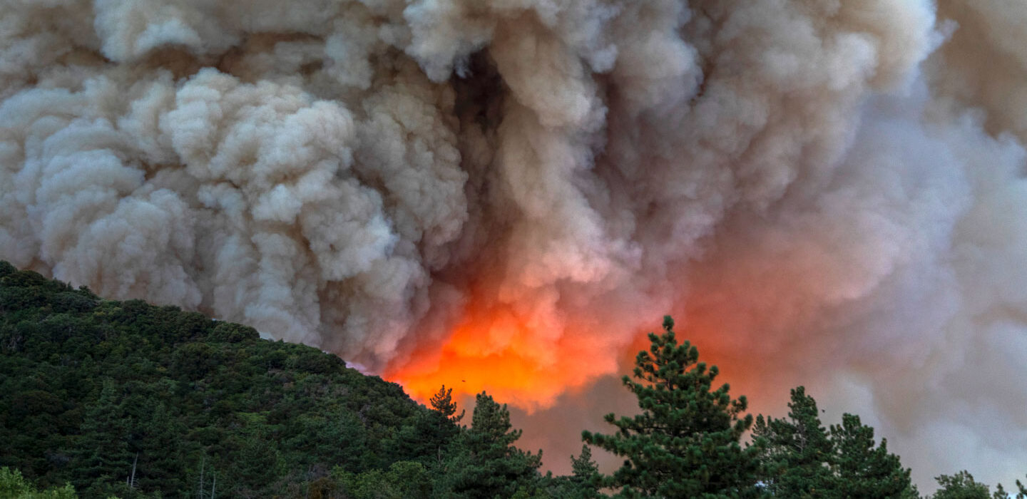 smoke billows above a wildfire in California