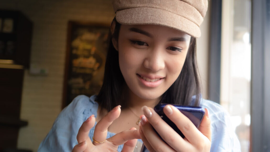 a teen girl taps a smartphone touch screen