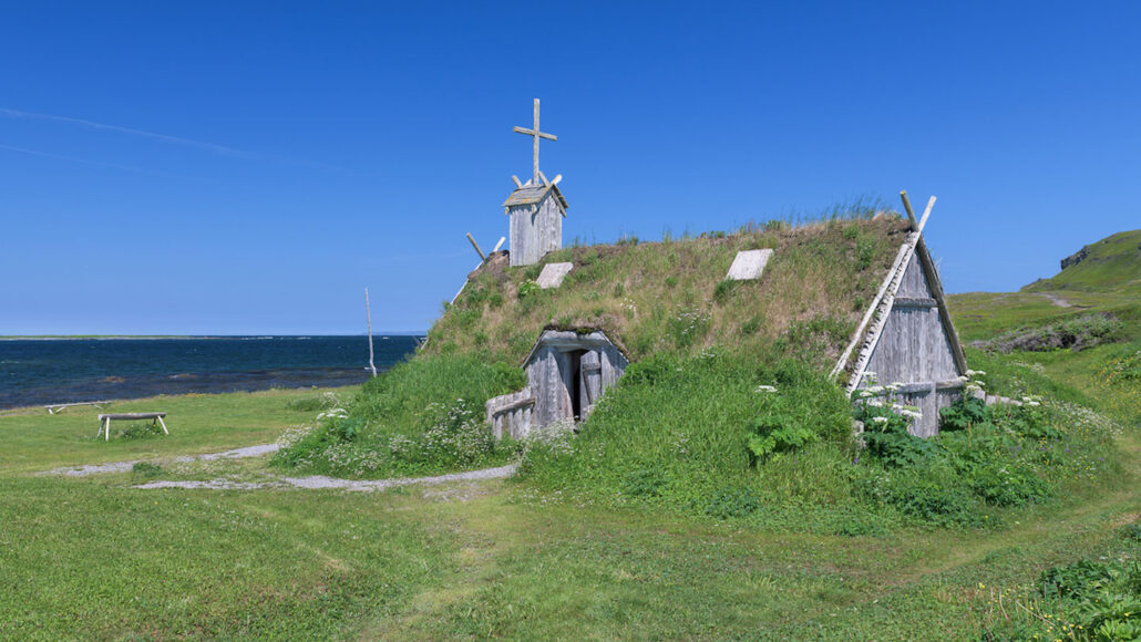 A reconstructed Viking Age hut with an overgrown roof in Newfoundland