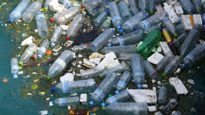 dozens of plastic bottles and other bits of plastic trash pollute a waterway