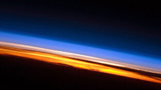 image of Earth's atmosphere with the troposphere visible in orange