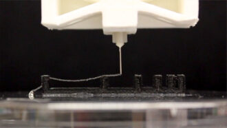 a photo of a 3-D printer squirting out a stream of ink made of bacteria