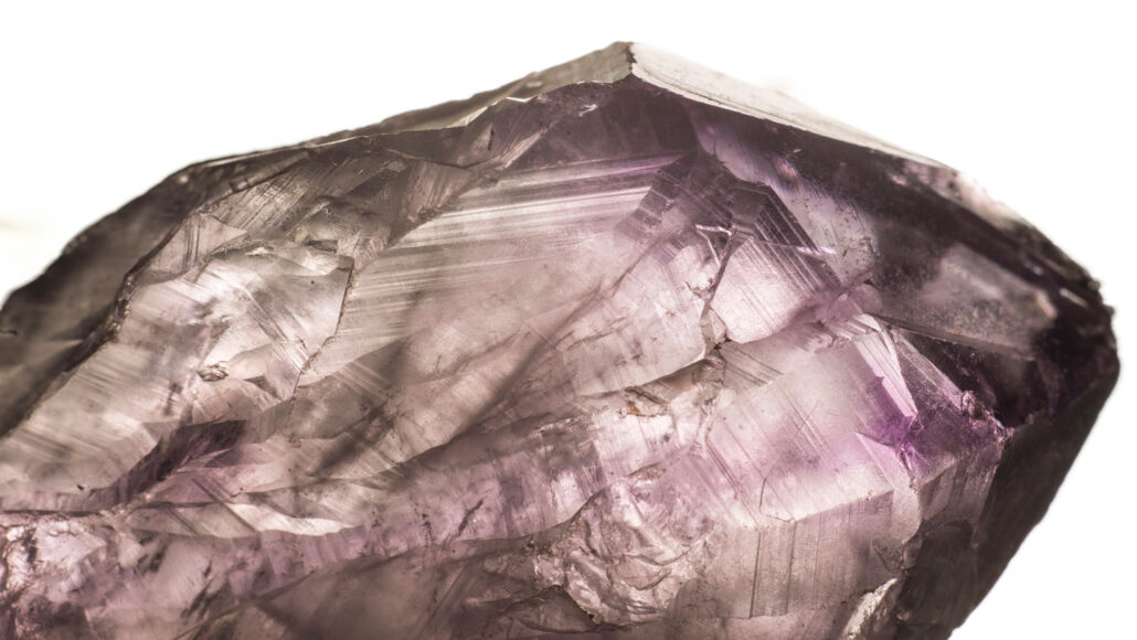 a close up photo of a piece of translucent purple quartz