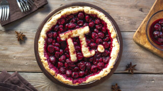 a cherry pi with some of the crust arranged in the shape of the Greek letter pi