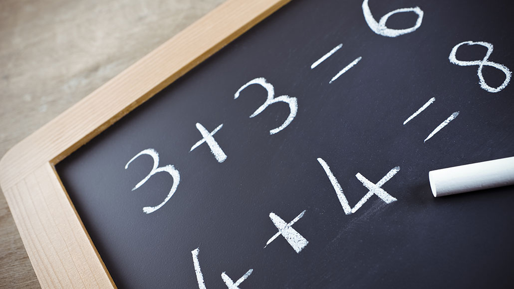 a photo of a blackboard on a table. Written on the board is 3+3=4 and 4+4=8