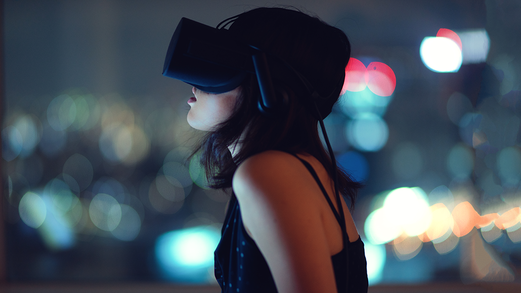 a photo of a young woman wearing VR goggles against a blurry background
