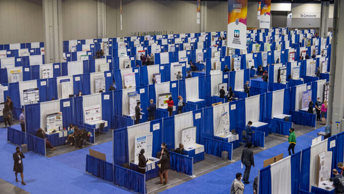 a convention center hall is filled with rows of blue booths for science fair competitors to show off their projects