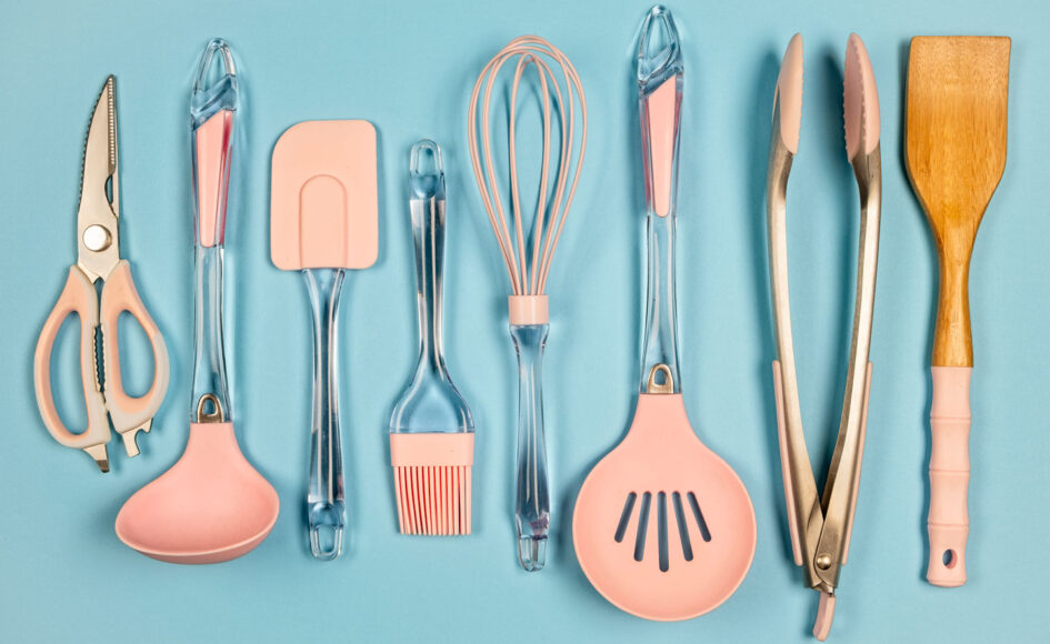 a row of spatulas, tongs, ladles and other kitchen tools with pink silicone pieces