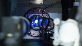 a closeup of machinery shows, through a lens, a bright glowing white ball