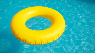 a photo of a yellow inner tube floating on blue pool water