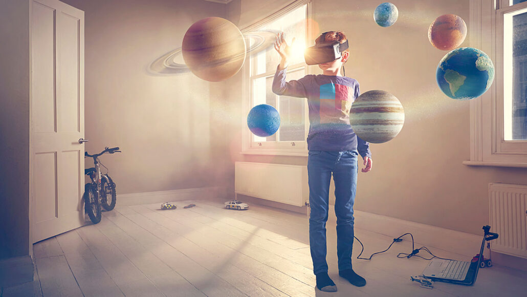 a boy wearing a VR headset stands in a bedroom where Earth, Jupiter and other planets float in the air