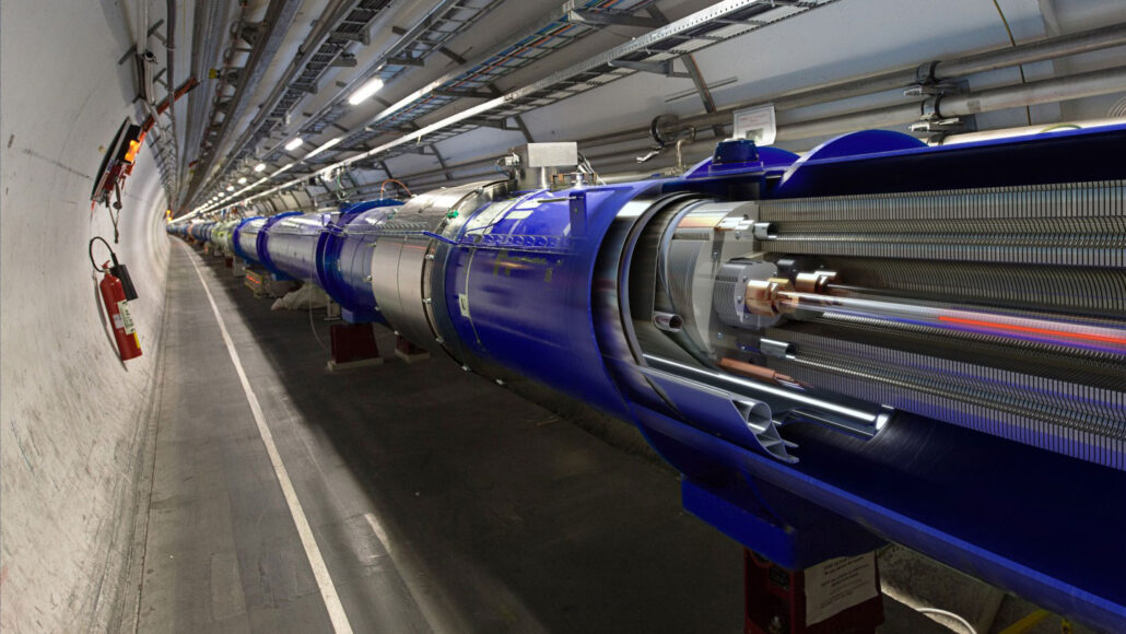 a complex, tube-shaped piece of machinery extends down a long tunnel