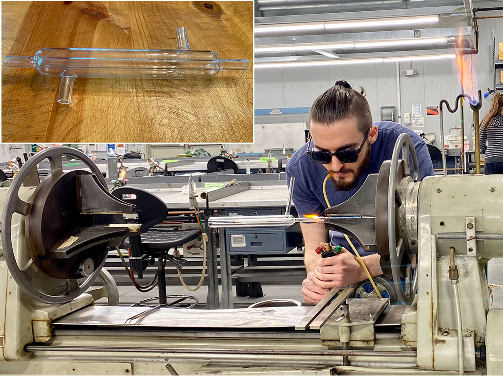 a photo of a young man with a ponytail using a machine to create laboratory glassware