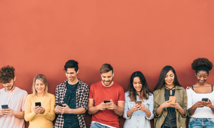 a line of teens of various genders and races all looking down at their phones