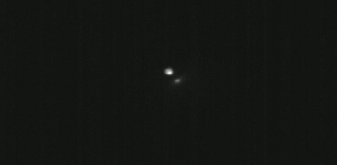 A gif of two asteroids, one of which was hit by a spacecraft to change its orbit.