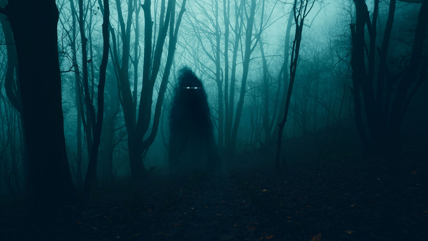 a shadowy figure with glowing eyes stands in a dark, misty forest