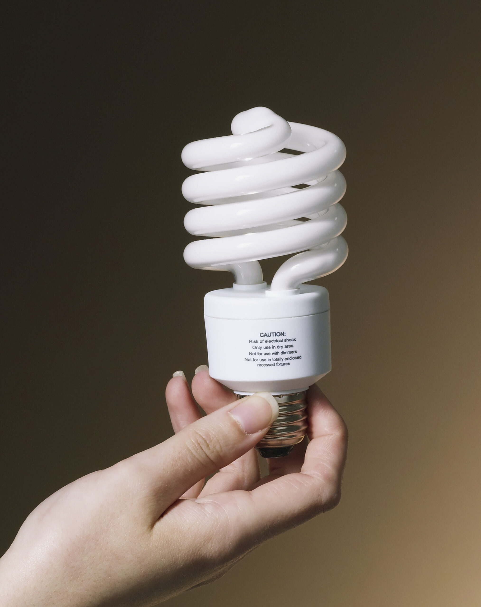 a hand holds up a fluorescent light bulb