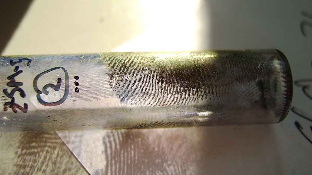 a photo of dark brown prints on a glass vial