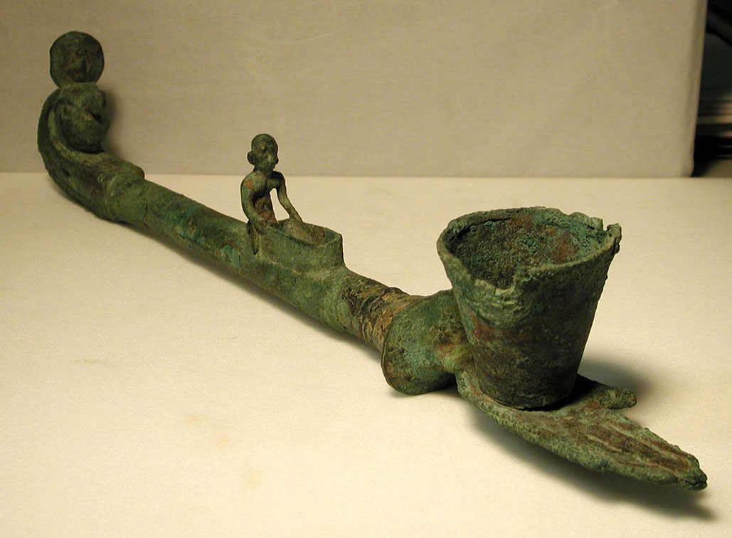 a bronze incense burner with a green patina