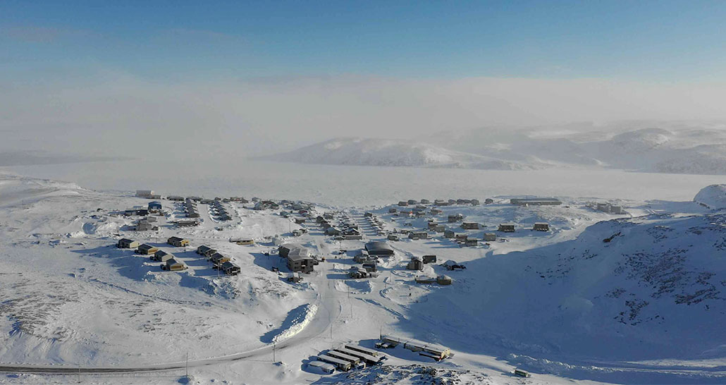 an aerial view of Ivujivik, a small viillage in a frozen landscape