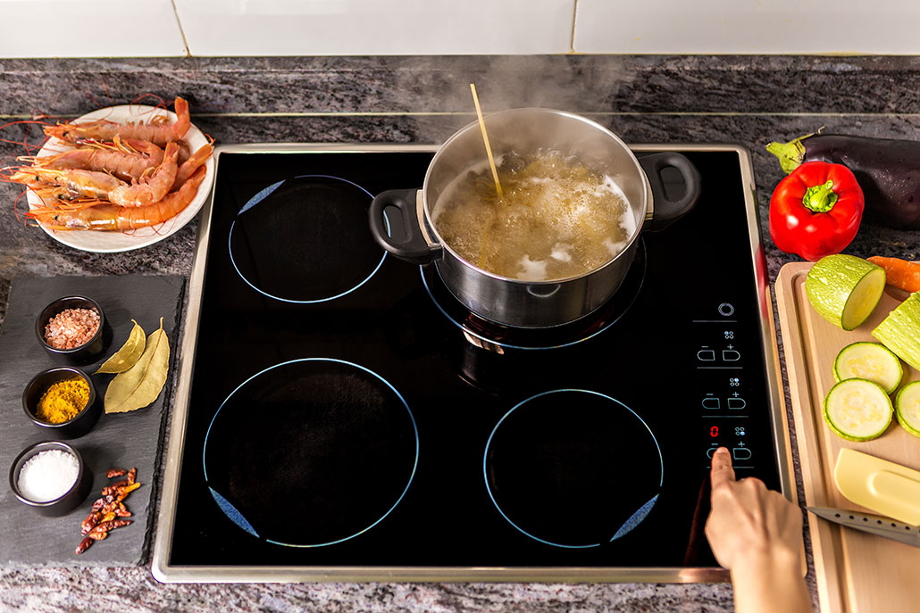a photo of a steaming pot of soup cooking on an induction cooktop