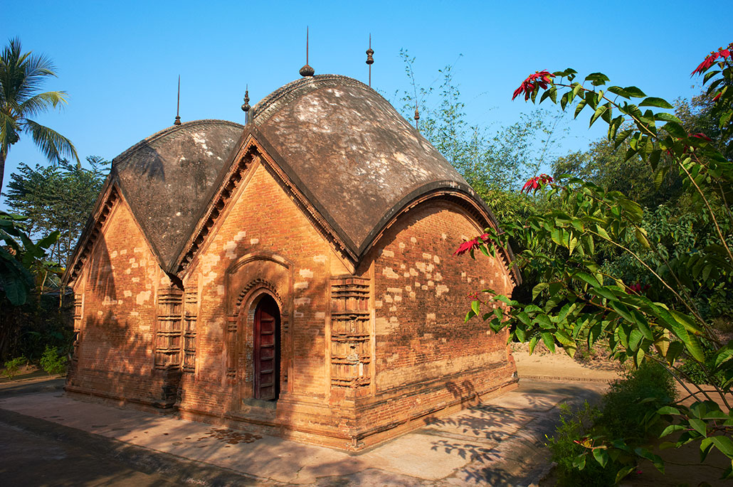 a small earthern brick stucture with a striking curved roof